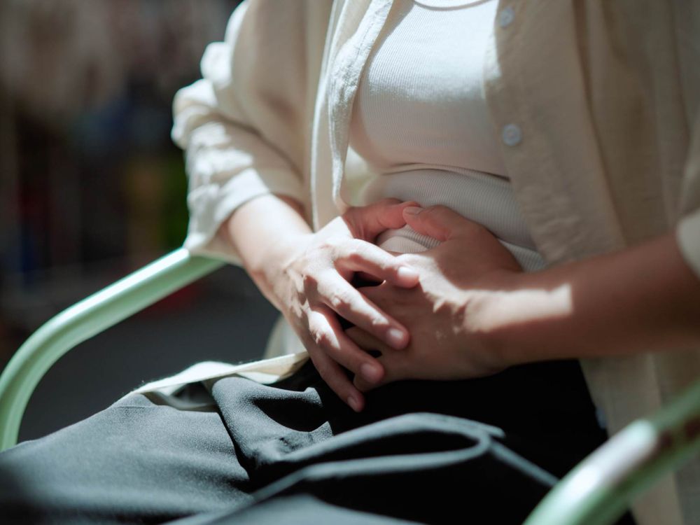 donna con dolori e crampi addominali a causa del ciclo mestruale